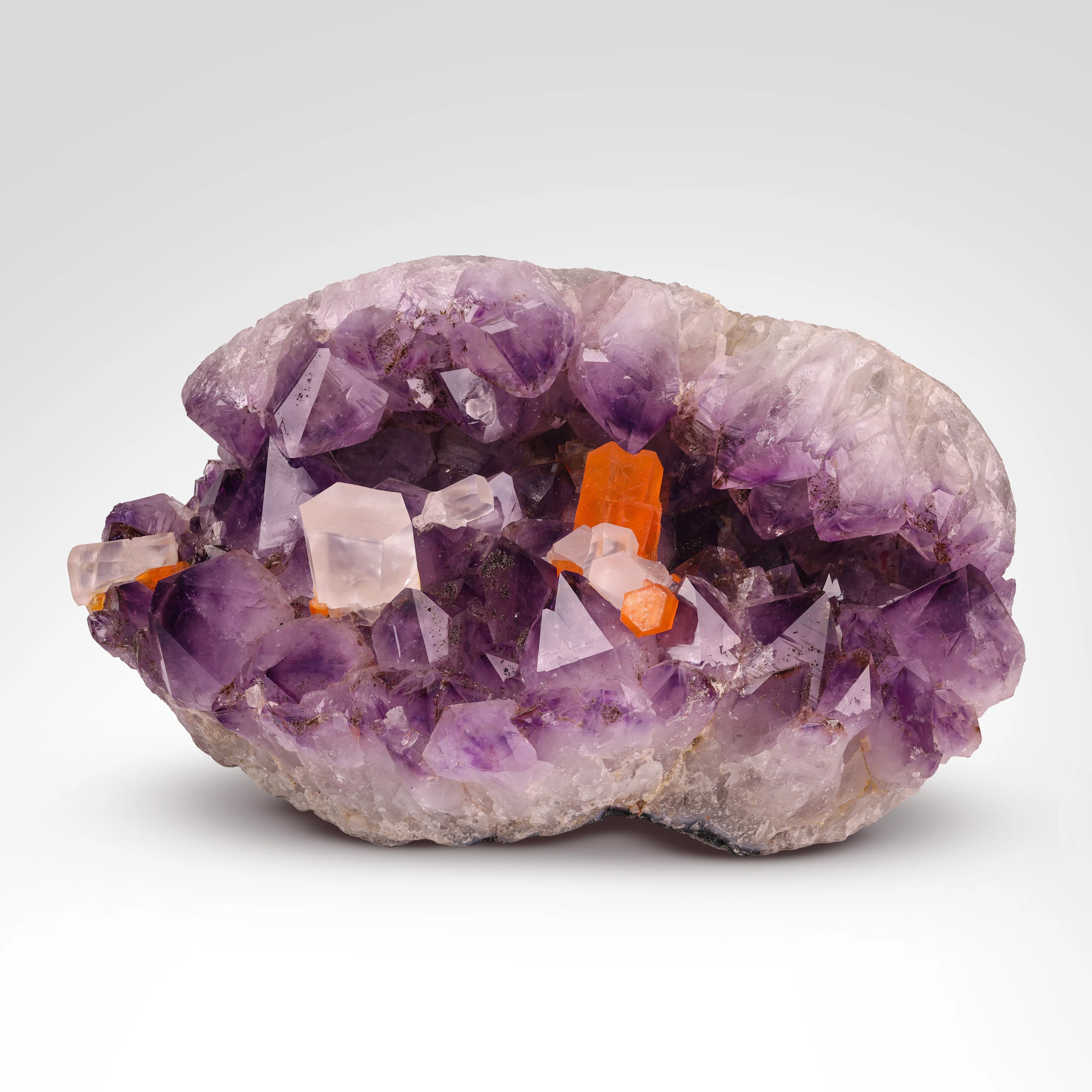 Brilliant Orange Calcite in Amethyst Geode - image 1