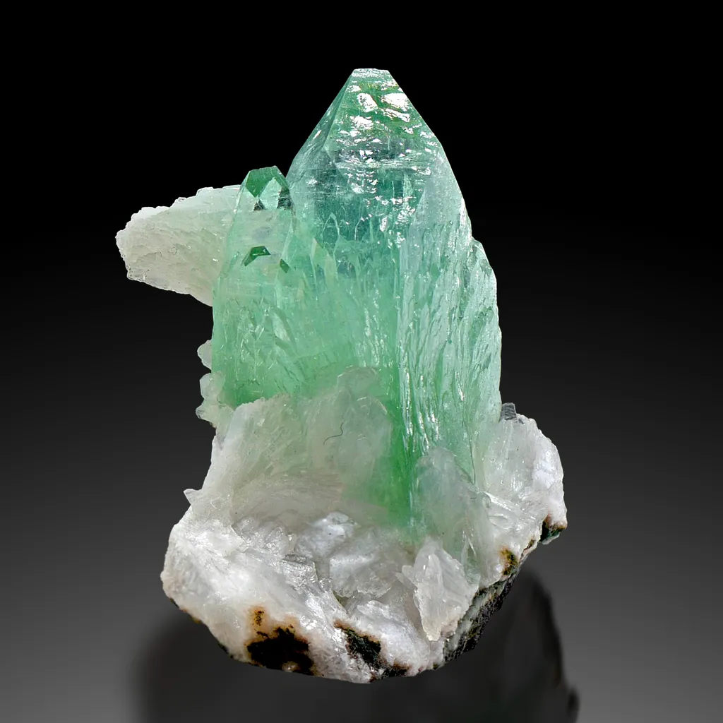 Green Apophyllite from Maharashtra, India. Glassy, transparent and lustrous crystals. Exhibits highly desirable deep color with stilbite image