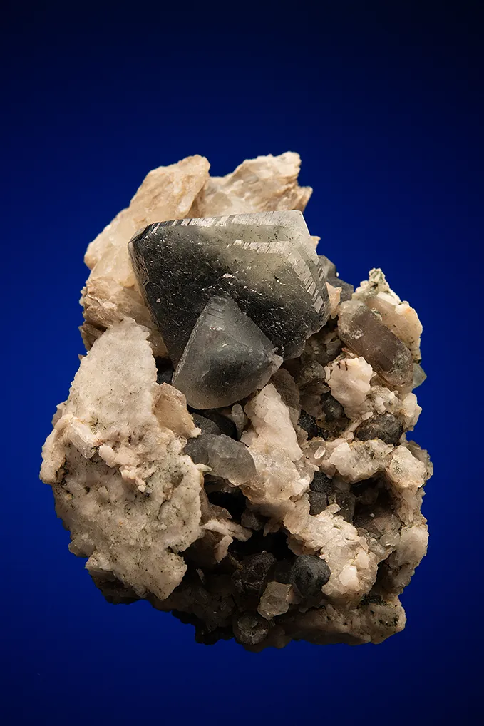 Phenakite on Quartz var. Smoky and Calcite image