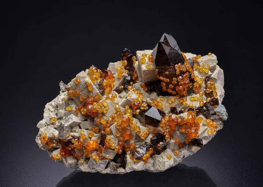 Spessartine on Smoky Quartz on Microcline image